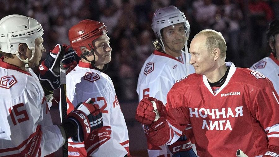 Vladimir Putin  mengenakan seragam berwarna merah dengan nomer 11