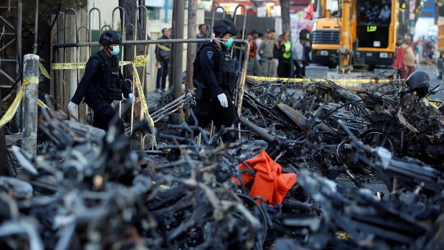 Members of the Indonesian Special Forces Police counter-terrorism squad walk by burned motorcycles following a blast at the Pentecost Church Central Surabaya (GPPS), in Surabaya, Indonesia May 13, 2018. REUTERS/Beawiharta