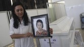 Maria Hamdani, memasang foto bibinya, Mayawati di Rumah Persemayaman Gotong Royong, Malang, Jawa Timur, Senin (14/5). Tercatat hingga Senin (14/5) petang jumlah korban jiwa dalam rentetan teror bom di Surabaya mencapai 25 orag--13 pelaku, sisanya warga. (ANTARA FOTO/Ari Bowo Sucipto)