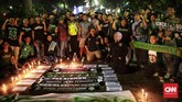 Sejumlah Bonek foto bersama seorang polisi yang menjaga aksi simpati untuk korban bom Surabaya di Taman Suropati, Jakarta. (CNN Indonesia/Andry Novelino)