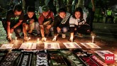 Sejumlah Bonek menyalakan lilin sebagai aksi simpati. Total ada 25 orang meninggal karena aksi teror bom di Surabaya dan Sidoarjo. (CNN Indonesia/Andry Novelino)