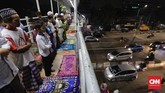 Tak hanya memanfaatkan jalanan di sela-sela ruko tempat jualan, sejumlah warga kawasan Pasar Gembrong, Jakarta juga tampak menjalankan salat tarawih pertamanya di jembatan penyeberangan orang. (CNN Indonesia/Adhi Wicaksono)