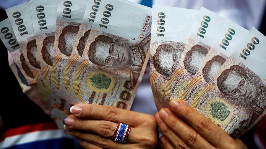 thai bath FILE PHOTO: Anti-government protesters hold Thai baht banknotes ready to donate to their leader marching in downtown Bangkok February 7, 2014. REUTERS/Damir Sagolj/File Photo