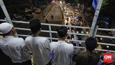 Di antara riuh jalanan, suara mesin kendaraan, beberapa orang tampak tetap khusyuk menjalankan salat tarawih di atas jembatan penyeberangan, di kawasan Pasar Gembrong. (CNN Indonesia/Adhi Wicaksono)