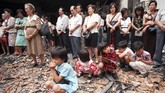 Anak-anak penganut agama Kristen duduk di reruntuhan gereja dan mengikuti kebaktian pada pada 29 November 1998. Kerusuhan 1998 juga menyebabkan 22 gereja di Jakarta dirangsek massa dan dihancurkan. (AFP PHOTO/KEMAL JUFRI)