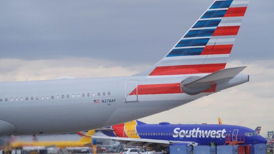 An airplane passes in front of Southwest Airlines Flight 1380, which diverted to the Philadelphia International Airport this morning after the airline crew reported damage to one of the aircraft's engines, on a runway in Philadelphia, Pennsylvania U.S. April 17, 2018. REUTERS/Mark Makela