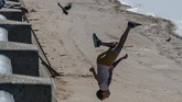 Seorang remaja Rusia berlatih parkour pada sebuah pantai yang terletak dekat sungai Volga di Samara. Kota itu akan terpilih menjadi salah satu tuan rumah Piala Dunia 2018. (AFP PHOTO / Mladen ANTONOV)
