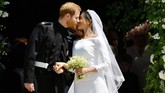 Setelah sah sebagai suami istri, Pangeran Harry dan Meghan Markle keluar dari St. George dan berciuman di tangga gereja sebelum menaiki kereta kencana yang ditarik kuda. (Ben Birchall/Pool via REUTERS)