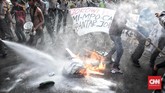 Petugas lalu berbuat sigap dengan berupaya memadamkan api yang membakar ban yang dikobarkan dengan sengaja oleh para mahasiswa pelaku aksi Refleksi 20 tahun Reformasi. (CNN Indonesia/Andry Novelino)