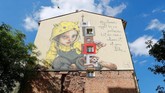 Mural karya artis urban Herakut ini dipajang di tembok luar salah satu kompleks hunian warga Berlin. (REUTERS/Fabrizio Bensch)