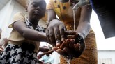 Selain pemberian vaksin, pentingnya menjaga kebersihan juga disebarluaskan. Seorang anak mencuci tangannya sebagai upaya pencegahan melawan ebola di gereja di Mbandaka, Kongo. (REUTERS/Kenny Katombe)