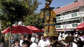 Seorang anak yang mengenakan kostum berdiri di tengah kerumunan orang dalam Bun Festival di Pulau Cheung Chau, Hong Kong, pada Selasa (22/5).