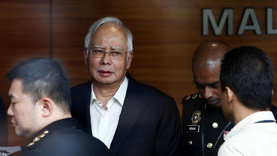 Polisi berpakaian preman menggeledah sebuah rumah di kawasan Putrajaya, Malaysia, terkait kasus 1MDB.