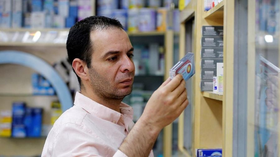 A Palestinian pharmacist holds a medicine box in a pharmacy in Hebron, in the occupied West Bank May 23, 2018. Picture taken May 23, 2018. REUTERS/Mussa Qawasma