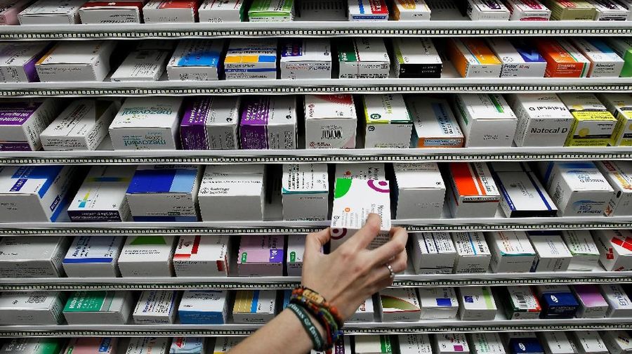 A pharmacist takes a box of the medicine 