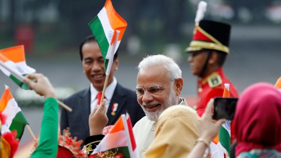 Indian Prime Minister Narendra Modi (R) is greeted by the children in traditional costumes as Indonesia President Joko Widodo (L) looks on at the presidential palace in Jakarta, Indonesia May 30, 2018.  REUTERS/Darren Whiteside