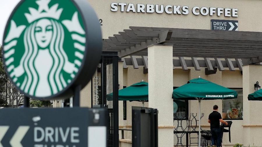 A worker puts away patio furniture at a Starbucks Corp drive-through location closes down this afternoon for anti-bias training as the coffee chain closed all 8,000 of their company-owned cafes in the U.S. including this location in Oceanside, California, U,S. May 29, 2018.    REUTERS/Mike Blake