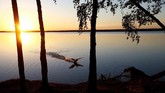 Matahari terbenam di belakang sebuah danau di dekat kota Vileika, Belarusia. (REUTERS/Vasily Fedosenko)
