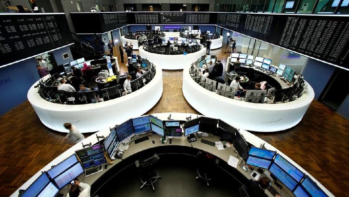 FILE PHOTO: Traders work at their desks in front of the German share price index, DAX board, at the stock exchange in Frankfurt, Germany February 28, 2017. REUTERS/Staff/Remote/File Photo