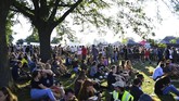 Para pengunjung duduk di bawah terik sinar matahari saat mengikuti Field Day Festival di Brockwell Park, London, 2 Juni 2018. Setiap tahunnya, Field Day Festival diadakan di taman di ibu kota Britania Raya tersebut. (REUTERS/Dylan Martinez)