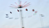 Para pengunjung Field Day dapat menikmati berbagai wahana untuk bersenang-senang, salah satunya seperti ontang anting. (REUTERS/Dylan Martinez)