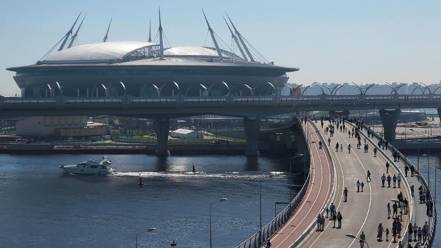 People walk on Yahtenny bridge connecting the southern coast of the city's Primorsky district and Krestovsky Island with the Saint Petersburg Stadium, which will host matches of the 2018 FIFA World Cup, in St. Petersburg, Russia May 13, 2018. REUTERS/Anton Vaganov