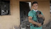 Walter Amilcar Garcia, misalnya, baru saja menyelamatkan anjing peliharaan abangnya di depan rumah di Escuintla yang hancur akibat erupsi Gunung Fuego. (Reuters/Carlos Jasso)