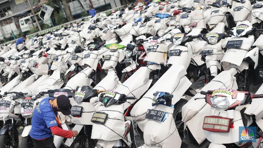 Petugas merapihkan kendaraan motor yang akan dibawa keluar kota di Stasiun Barang Kampung Bandan, Jakarta Kamis (7/6). Kemenhub juga menggelar program pengiriman sepeda motor secara gratis untuk menurunkan angka kecelakaan pemudik yang menggunakan kendaraan roda dua. Persyaratan agar motor dapat dikirim secara gratis, pemudik harus menyiapkan data diri dan membawa KTP SIM, KK dan, STNK. Portrait pemudik, Diki 27 tahun sudah menggunakan jasa angkutan gratis dari Kemenhub. Menurut dia program ini sangat memudahkan warga untuk mudik. Ribuan motor tersebut akan dikirim besok pada 8 Juni 2018. (CNBC Indonesia/Muhammad Sabki)