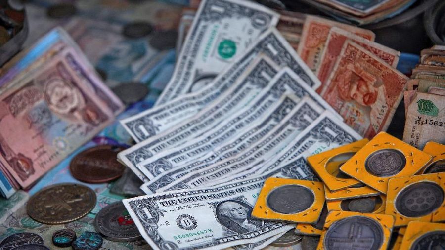 FILE PHOTO: U.S. dollar bills lie with old coins and currency notes at a money changer booth along a road in Karachi, Pakistan December 29, 2011. REUTERS/Akhtar Soomro/File Photo