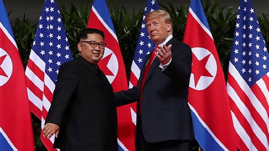 Presiden Amerika Serikat (AS) Donald Trump dan pemimpin Korea Utara, Kim Jong Un, akhirnya saling berjabat tangan dalam tatap muka pertama mereka