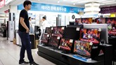 Seolah tak membiarkan seorang pun ketinggalan kabar besar ini, toko elektronik di Korea Selatan turut menayangkan beritanya di etalase televisi yang dijual. (REUTERS/Kim Hong-Ji)