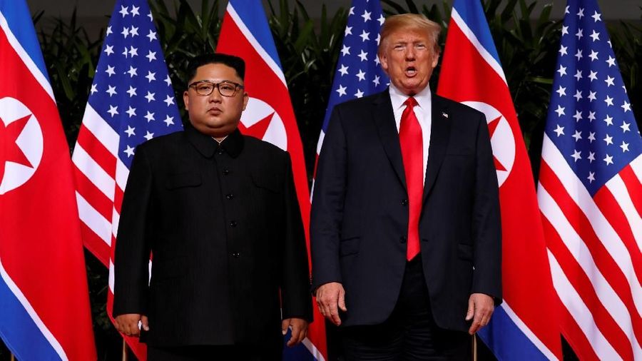 Presiden Amerika Serikat (AS) Donald Trump dan pemimpin Korea Utara, Kim Jong Un, akhirnya saling berjabat tangan dalam tatap muka pertama mereka
