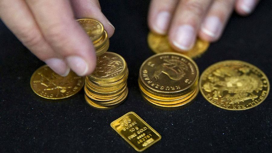 FILE PHOTO: A worker places gold coins on display at Hatton Garden Metals precious metal dealers in London, Britain July 21, 2015. REUTERS/Neil Hall/File Photo