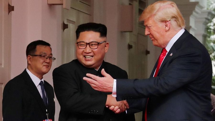 Presiden Amerika Serikat (AS) Donald Trump dan pemimpin Korea Utara, Kim Jong Un, akhirnya saling berjabat tangan dalam tatap muka pertama mereka