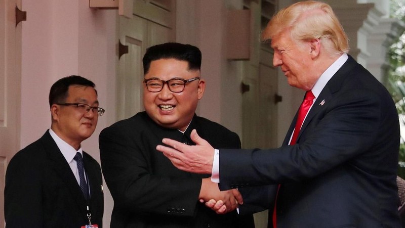 Presiden Amerika Serikat (AS) Donald Trump dan pemimpin Korea Utara, Kim Jong Un, akhirnya saling berjabat tangan dalam tatap muka pertama mereka