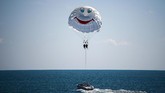 Pasangan kekasih menikmati parasail di sepanjang pantai dekat Stadion Olimpiade Fisht di Sochi, Rusia, jelang penyelenggaraan Piala Dunia 2018. (AFP PHOTO / Jewel SAMAD)
