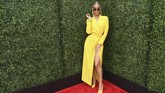 Jasmine Sanders menghadiri MTV Awards 2018 dengan gaun blazer berwarna mencolok. Dia memilih gaun berwarna kuning lengkap dengan heels kuningnya. Namun dia menambahkan aksesori sunglasses kecil berwarna hitam. (Emma McIntyre/Getty Images for MTV/AFP)