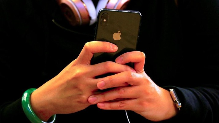 FILE PHOTO: A customer holds the iPhone X during the global launch of the new Apple product in central Sydney, Australia, November 3, 2017.     REUTERS/David Gray/File Photo