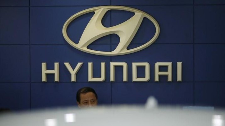 An employee sits in front of the logo of Hyundai Motor Co. at its dealership in Seoul, South Korea, October 22, 2015. REUTERS/Kim Hong-Ji