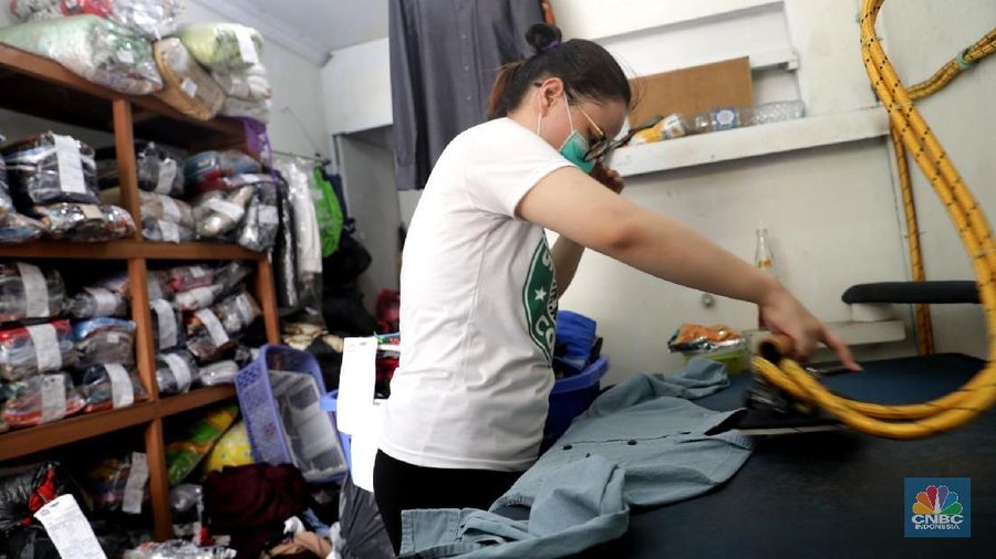 Pekerja saat menyetrika pakaian laundry di tempat jasa cuci setrika pakaian Jakarta, Rabu (20/6). Tingginyan kebutuhan akan mencuci dan menyetrika pakaian di saat libur lebaran atau Idul Fitri membuat berbagai usaha Laundry kebanjiran order jasa mencuci dan menyetrika hingga 90% ketimbang hari biasa. Dalam sehari laundry mampu menampung hingga ratusan kilo pakaian. Menurut pegawai laundry, musim libur panjang ini juga membuat jasa laundry mampu meraih untung hingga 5 juta dalam 2 hari. Jasa laundry menjadi alternatif membantu menyelesaikan pekerjaan rumah, apalagi saat bulan libur lebaran. Karena banyak dari mereka yang memiliki asisten rumah tangga belum pulang dari kampung halaman. (CNBC Indonesia/Muhammad Sabki)