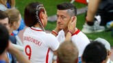 Striker Polandia Robert Lewandowski dihibur sang istri, Anna, setelah Polandia kalah 1-2 dari Senegal. (REUTERS/Kai Pfaffenbach)