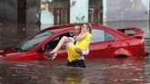 Seorang perempuan diselamatkan dari mobilnya yang terkena banjir di jalanan kota Nizhny Novgorod, Rusia. (Reuters/Murad Sezer)