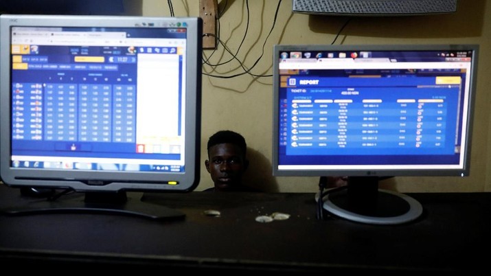 A man sits behind computer systems displaying betting numbers at a betting house in Ladipo district, in Lagos, Nigeria, June 6, 2018. Picture taken June 6, 2018.REUTERS/Akintunde Akinleye