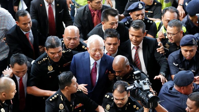 Dengan mengenakan setelah berwarna biru tua dan dasi merah, Najib membantah melakukan kesalahan apapun sejak kabar tentang skandal ini muncul.