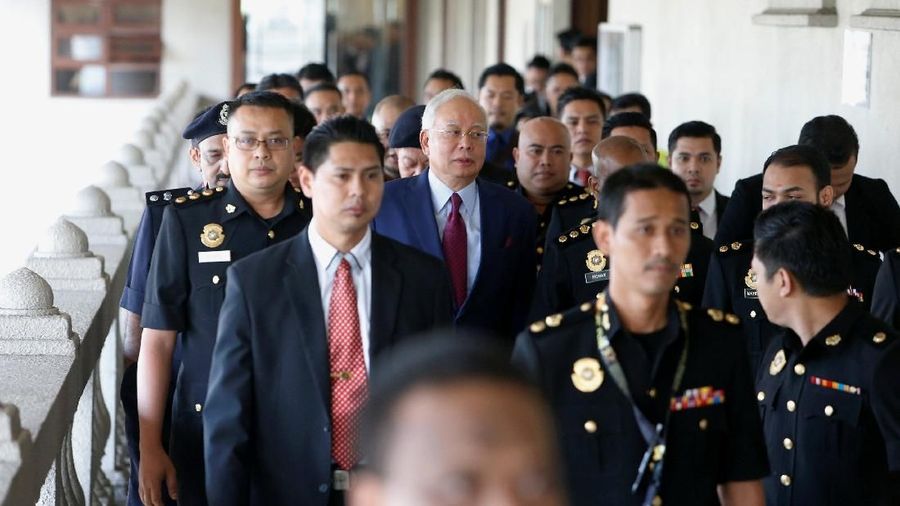 Dengan mengenakan setelah berwarna biru tua dan dasi merah, Najib membantah melakukan kesalahan apapun sejak kabar tentang skandal ini muncul.