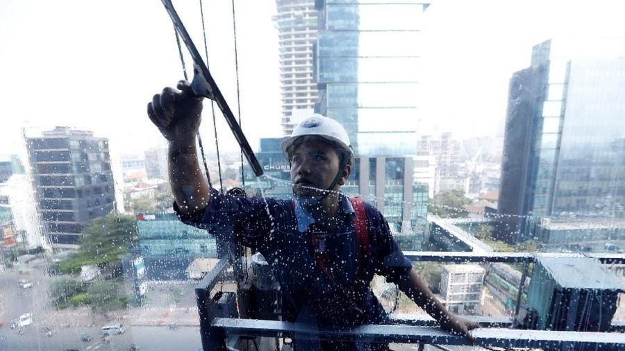 A window washer cleans an office tower's window in central Jakarta, Indonesia July 4, 2018. REUTERS/Darren Whiteside