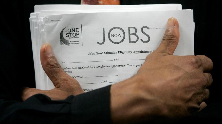 FILE PHOTO: A man carrying a stack of job listings listens to a discussion at the One Stop employment center in San Francisco, California, August 12, 2009.  REUTERS/Robert Galbraith/File Photo                          GLOBAL BUSINESS WEEK AHEAD