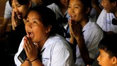 Doa suka cita didaraskan siswa Sekolah Mae Sai Prasitsart, Chiang Rai, Thailand setelah guru mereka mengumumkan bahwa teman sekelas mereka yang terjebak di gua telah berhasil diselamatkan, Senin (9/7). (REUTERS/Tyrone Siu TPX IMAGES OF THE DAY)