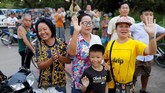 Warga di pinggir jalan melambaikan tangan ke arah ambulans yang membawa para remaja anggota tim sepak bola Wild Boars dan pelatihnya yang berhasil diselamatkan setelah terjebak selama tiga pekan di Gua Tham Luang, Chiang Rai, Thailand. (REUTERS/Tyrone Siu)