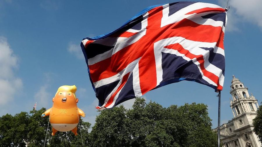 Demonstrators float a blimp portraying U.S. President Donald Trump, next to a Union Flag above Parliament Square, during the visit by Trump and First Lady Melania Trump in London, Britain July 13, 2018. REUTERS/Peter Nicholls